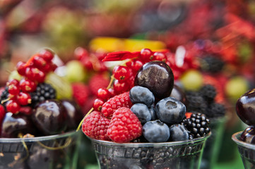 Selective view of assorted fruits in a plastic cup.