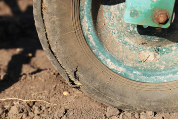 Damaged rubber wheel of a garden wheelbarrow.