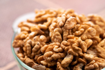 Studio photo of bowl with heap of peeled walnuts
