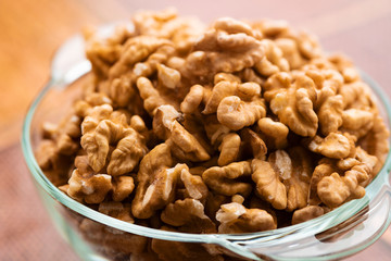 Studio photo of bowl with heap of peeled walnuts