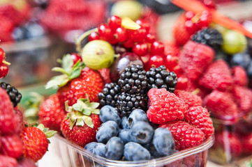Colorful assorted mix of strawberry, blueberry, raspberry, blackberry in a plastic cup