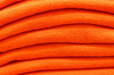 Stack of trend Orange Tiger woolen sweaters close-up, texture, background