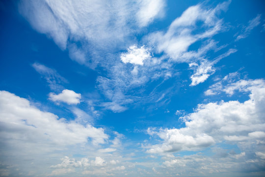 Deep blue sunny sky with white clouds. Blue sky with cloud closeup. White fluffy clouds in the blue sky.