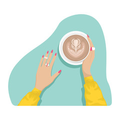 Women's hands with coral manicure and rings holding a Cup of cappuccino.