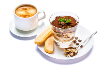 Classic tiramisu dessert in a glass cup, savoiardi cookies and coffee beans on white background with clipping path