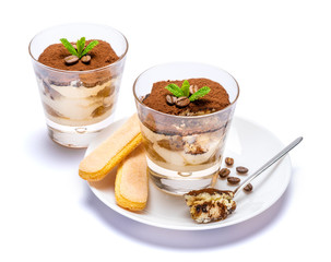 Classic tiramisu dessert in a glass cup on the plate on white background with clipping path