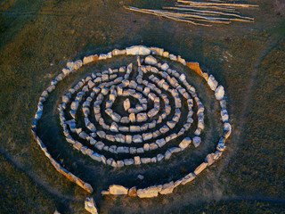 Fototapeta na wymiar Spiral labyrinth made of stones, top view from drone