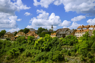 Fototapeta na wymiar clean old European city with beautiful colorful houses near park natural green natural space on blue sky with white clouds background 