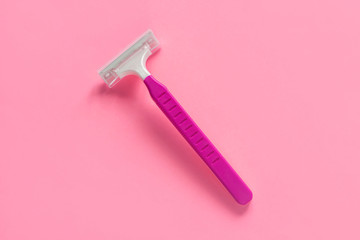 Disposable shaving machine for women on a pink pastel background, flatley, copy space.