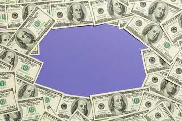Frame of one hundred dollar bills with empty space for your design. Top view of business concept on purple background with copy space