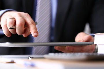 Male arm in suit and tie use silver pen and tablet pc