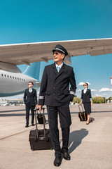 Attractive Caucasian pilot with suitcase walking in airport © Yakobchuk Olena
