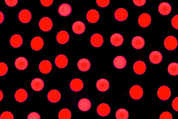 Unfocused abstract red bokeh on black background. defocused and blurred many round light