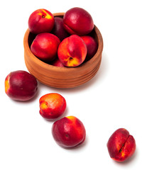 Ripe nectarine in clay pots on a white background