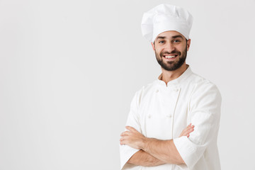 Young chef posing isolated over white wall background in uniform.