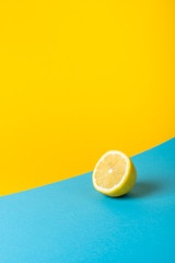Natural fresh juicy lemons on yellow and blue background