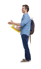 Side view of student man with the backpack and textbookswho stretches his hand for a handshake.
