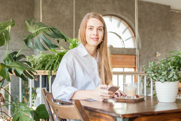 Business woman with smartphone working in open office place