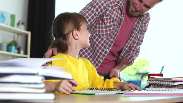 Dad checking daughter's  homework assignment and taking her for break