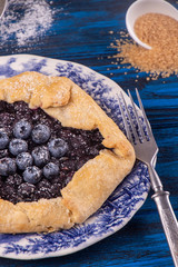 Summer sweet pie cake galette with  blueberry deep blue wooden background. Top view