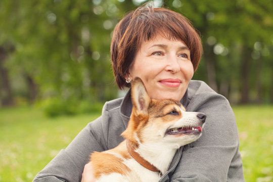 Mature Woman Hugging Corgi Puppy Dog  Outdoors