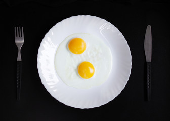 breakfast and light lunch or dinner. on a wooden table and with a black background. eggs cheese butter and coffee in white plate