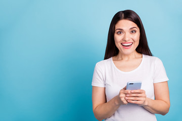 Photo of charming nice cute toothy crazy funny funky girlfriend seeing something unbelievable on her phone while isolated with blue background