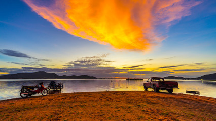 Fototapeta premium Old pickup truck and motercycle parked on the waterfront with sunset at Bang phra reservoir ,sriracha chon buri, thailand