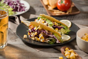 Traditional mexican taco with chicken and vegetables on wooden table. Latin american food.