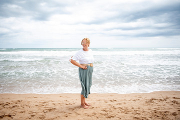 Fototapeta na wymiar Beautiful mature woman posing on the beach
