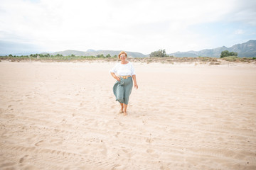 Beautiful mature woman posing on the beach