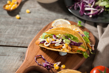Traditional mexican taco with chicken and vegetables on wooden table. Latin american food.