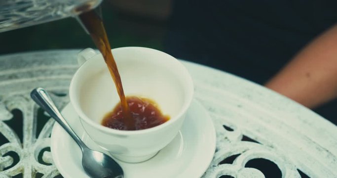 Close up shot of coffee being poured into cup