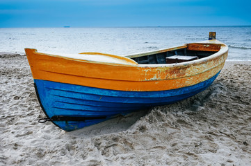 Naklejka premium Wooden fisher boat on coast, ocean