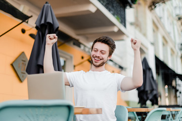 happy man excited about his win on laptop