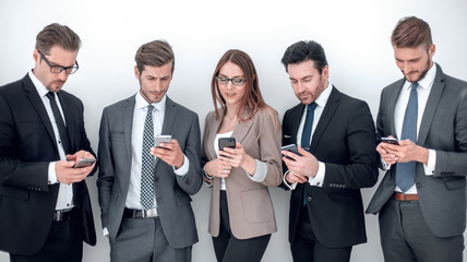 group of business people looking at the screens of their smartphones