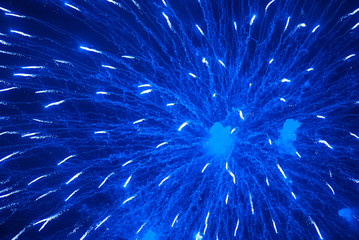 Blue firework in the night sky. Blue background