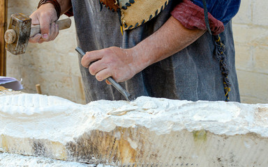 Stonemason With Ancient Costume During The Processing Of The Stone With Chisel