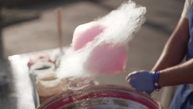 Close-up shot of a rolling a cotton candy stick in a machine