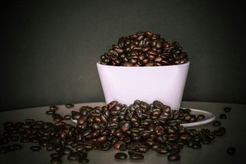 Coffee bean in white coffee cup on old wood. Background 