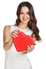 Young woman in white dress holds heart shaped box.