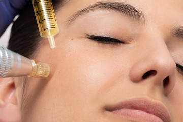 Face shot of woman at micro needle cosmetic treatment session.