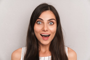 Image closeup of caucasian excited woman with long dark hair smiling and expressing surprise