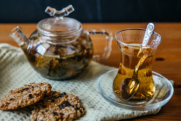 Herbal tea in a glass cup with cereal cookies