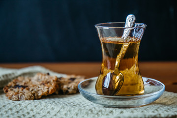 Herbal tea in a glass cup with cereal cookies