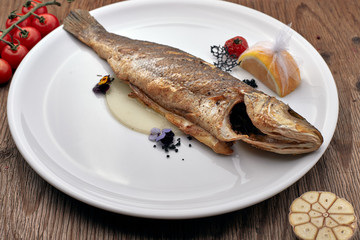 Fried Sibas fish on a white plate