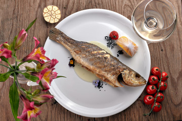 Fried Sibas fish on a white plate