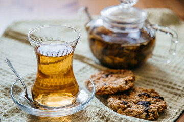 Herbal tea in a glass cup with cereal cookies