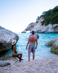 couple men and woman on summer vacation Sardinia, couple on the ebach of Cala Goloritze Sardegna Italy
