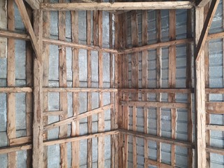 Inside view of old wooden roof wood structure with wooden beams in old barn